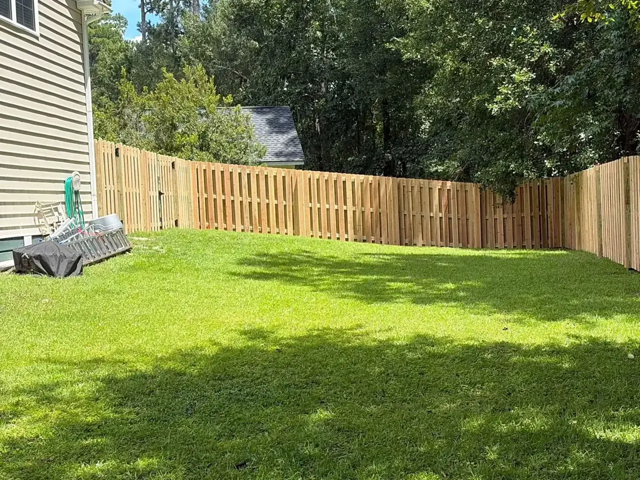 New natural wood privacy fence enclosing a lawn