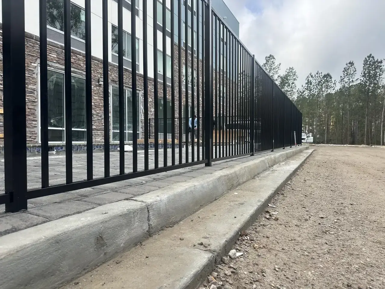 Black aluminum commercial fence installed on concrete
