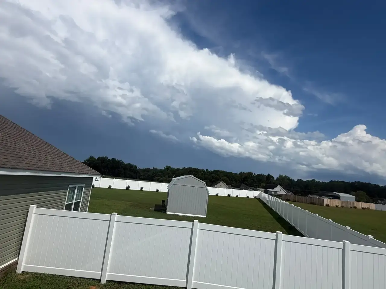 White vinyl fence enclosing a residential backyard