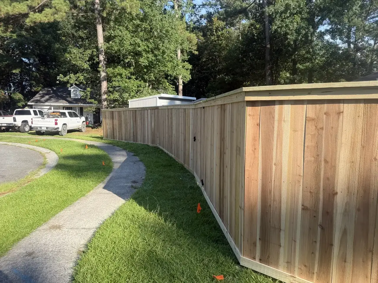 New Cap and Trim wood privacy fence beside a walkway